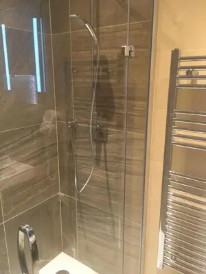 a bathroom with a glass shower with a toilet at Pension Karnet in Prague