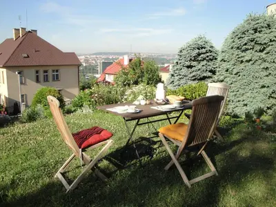 a table and two chairs sitting on the grass at Pension Apartment Granit in Prague