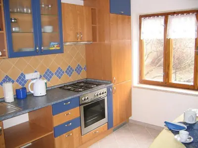 a kitchen with wooden cabinets and a stove top oven at Pension Apartment Granit in Prague