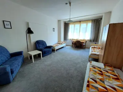 a living room with two blue chairs and a chandelier at Bonvolon in Prague