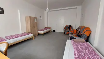 a room with three beds and a window at Bonvolon in Prague