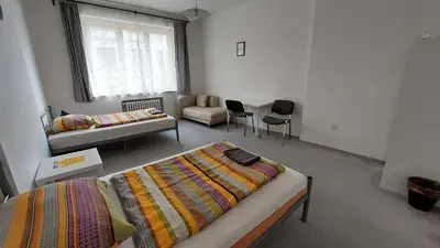 a room with two beds and a couch and a window at Bonvolon in Prague