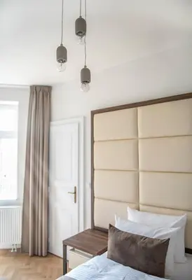a bedroom with a bed with a large headboard at Letna Garden Suites in Prague