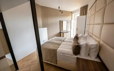 a bedroom with a large bed with white pillows at Letna Garden Suites in Prague