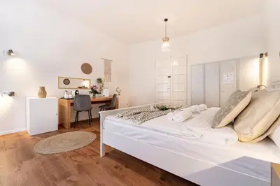 two beds in a bedroom with white walls and wood floors at Celine Prague Hostel in Prague