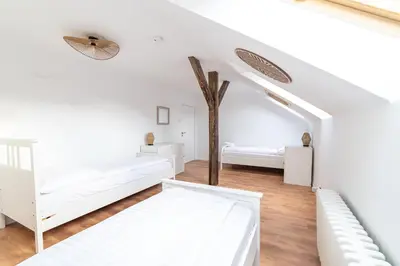 a living room with white furniture and windows at Celine Prague Hostel in Prague