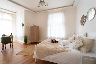 a living room with white furniture and a large window at Celine Prague Hostel in Prague
