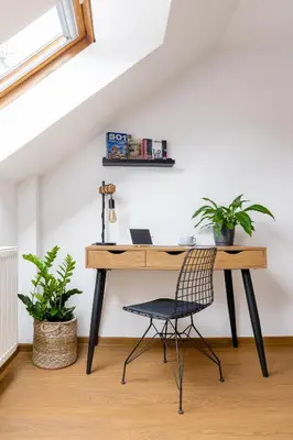a desk with a chair in a room with plants at Hotel Baroko in Prague