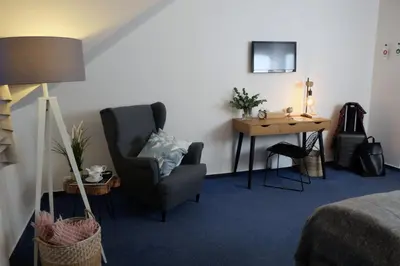a hotel room with a chair and a desk at Hotel Baroko in Prague