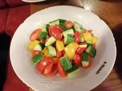 a white plate of vegetables on a table at River Star Hotel in Prague