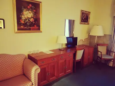 a hotel room with a desk with a couch and a chair at River Star Hotel in Prague