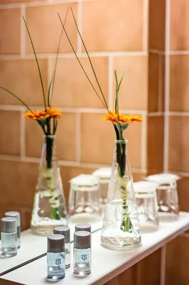 three glass vases with flowers in them on a table at Bona Serva in Prague
