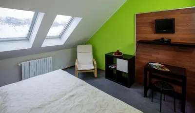 a bedroom with a bed and a desk and a tv at Bona Serva in Prague