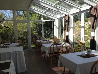 a restaurant with white tables and chairs and windows at Pension Filip in Prague