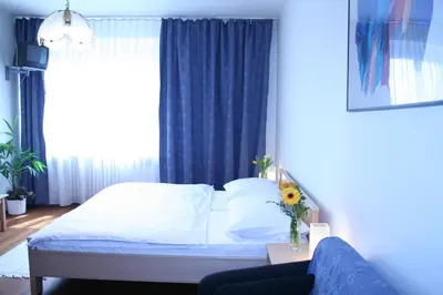 a bedroom with a bed and a blue curtain at Pension Filip in Prague