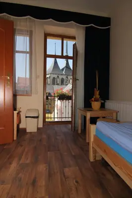 a bedroom with a bed and a view of a building at Hotel U Radnice in Louny