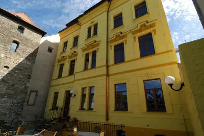 a yellow building with windows on a street at Hotel U Radnice in Louny