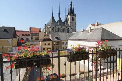 a view of a city with flowers on a balcony at Hotel U Radnice in Louny