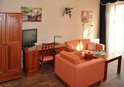a living room with a couch and a desk with a television at Hotel U Radnice in Louny
