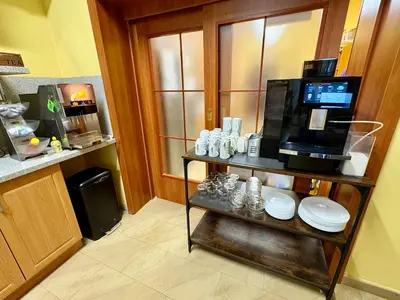 a kitchen with a coffee maker on a shelf with plates at Hotel U Radnice in Louny