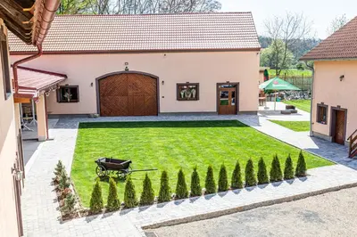 a garden with a wagon in front of a house at Apartmány Pod Řípem in Roudnice nad Labem