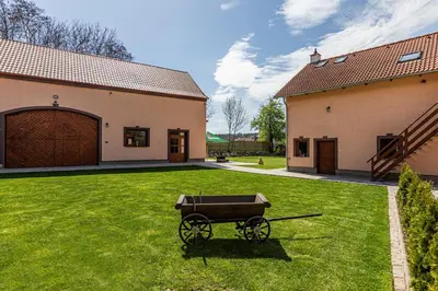 a horse drawn carriage in a yard next to a building at Apartmány Pod Řípem in Roudnice nad Labem