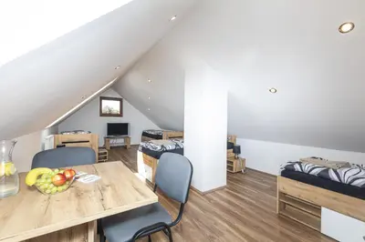 a living room with a table and chairs and a bed at Apartmány Pod Řípem in Roudnice nad Labem