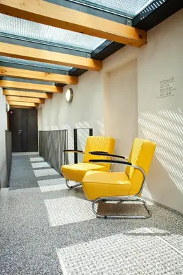 a row of yellow chairs in a hallway at Bellevue Hotel Benešov in Benešov