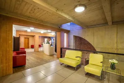 a lobby with two yellow chairs and a couch at Bellevue Hotel Benešov in Benešov