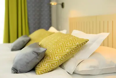a bed with four pillows on top of it at Bellevue Hotel Benešov in Benešov