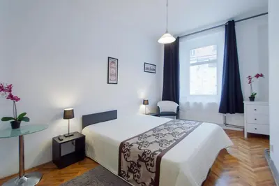 a bedroom with a bed and a table and a window at Modern Apartment Skolska 20 in Prague