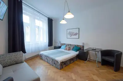 a bedroom with a bed and a couch and a window at Modern Apartment Skolska 20 in Prague