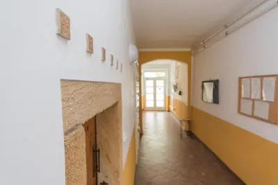 a hallway with a white wall with a fireplace at Pension U kostela in Český Brod