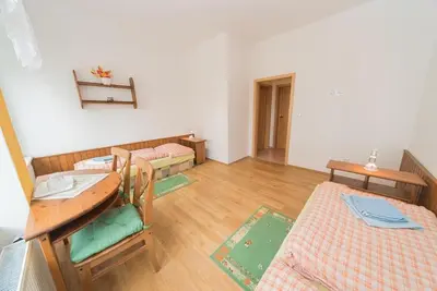 a room with two beds and a desk and a table at Pension U kostela in Český Brod