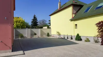 a driveway in front of a yellow building at Apartment De Luna in Prague
