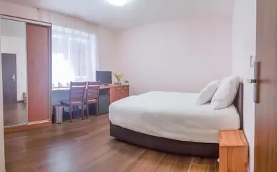 a bedroom with a bed and a desk and a table at Apartment De Luna in Prague