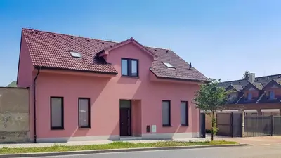 a pink house with a red roof at Apartment De Luna in Prague