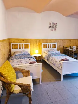 two beds in a room with wooden walls at Ubytování U Tajčů in Dolní Beřkovice