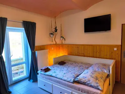 a bedroom with a large bed with two bags on it at Ubytování U Tajčů in Dolní Beřkovice
