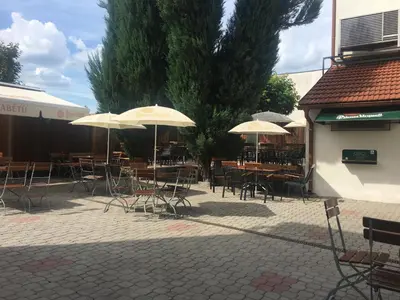 an outdoor patio with tables and chairs with umbrellas at Apartmán 3, Suvorovova 158 in Český Brod