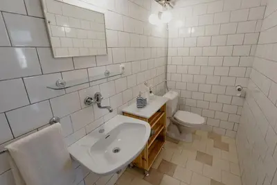 a white bathroom with a sink and a toilet at Apartmán 3, Suvorovova 158 in Český Brod