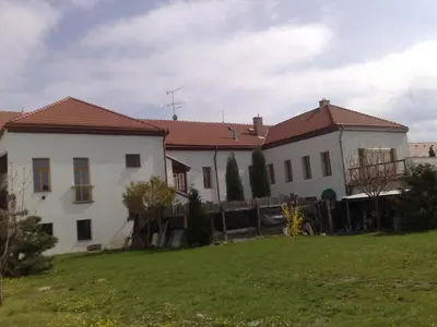 a white house with a fence in a yard at Apartmán 3, Suvorovova 158 in Český Brod