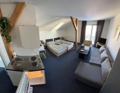 a bedroom with a bed and a mirror and a table at Penzion Ariane in Prague