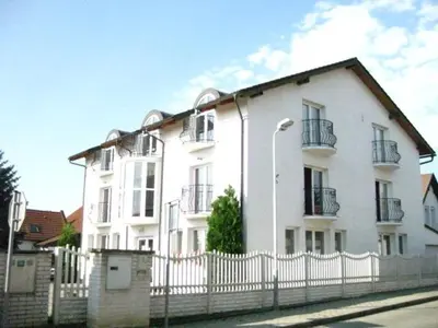 a white house with a fence in front of it at Penzion Ariane in Prague