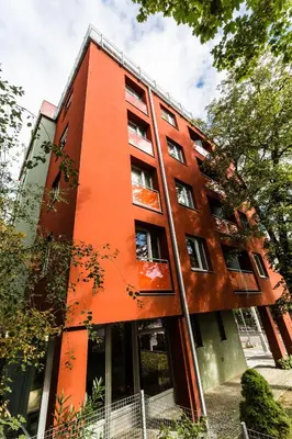 an orange building with trees in front of it at Penzion Palouček in Prague