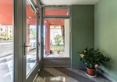 an open door with a potted plant and a window at Penzion Palouček in Prague