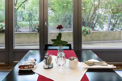 a table with a vase with a flower on it at Penzion Palouček in Prague