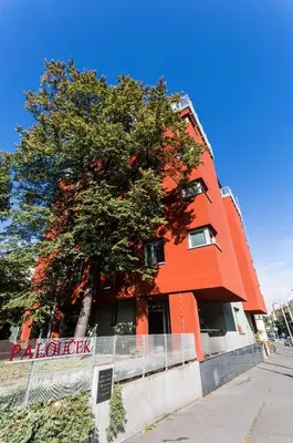 an orange building with a tree in front of it at Penzion Palouček in Prague