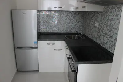 a white kitchen with a cross on the wall at Sekaninova 52 Retro Flat in Prague