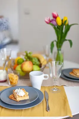 a table with two plates of food and a bowl of fruit at Prague Castle Garden Apartment in Prague